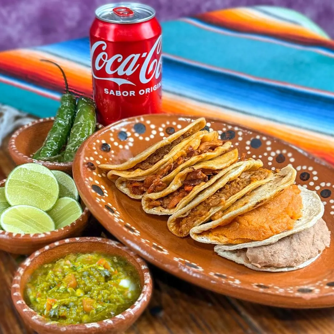 Tacos de canasta de La Mexicana en plato de barro con salsa, limón y chile toreado